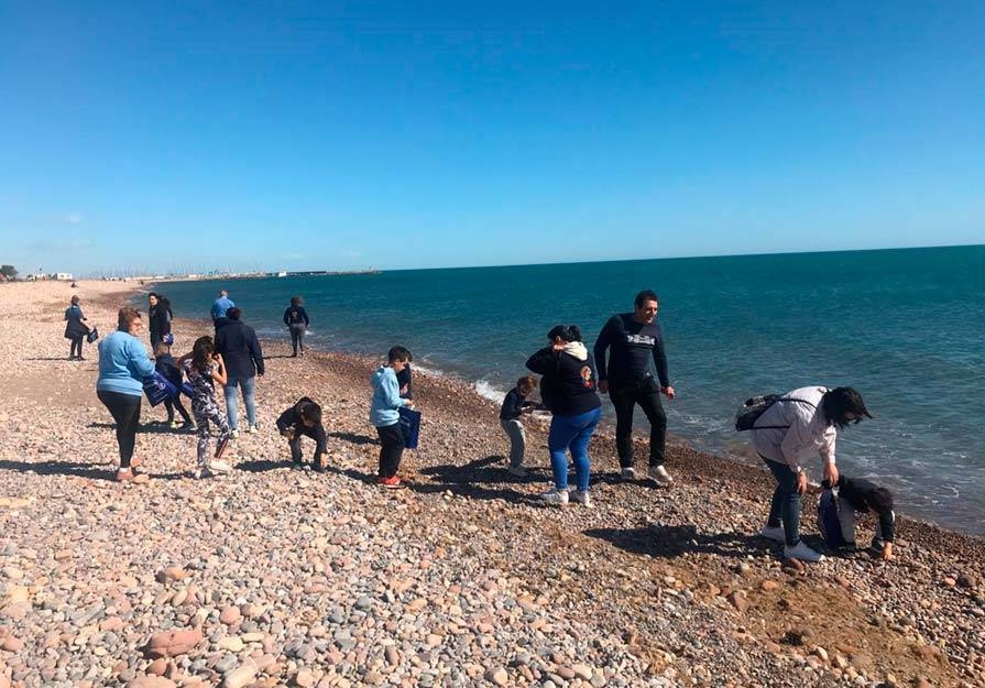 foto gente recogiendo residuos en la playa de sagunt