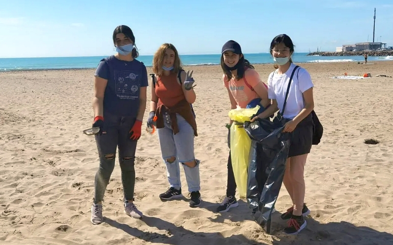 foto jovenes limpiando una playa